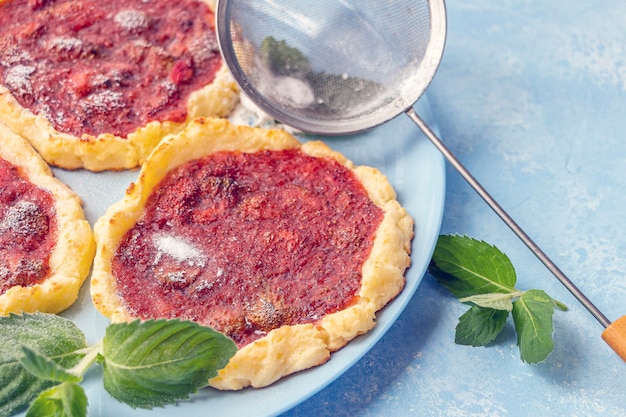 homemade strawberry tartlet gluten free berries biscuit summer dessert on blue plate decorated