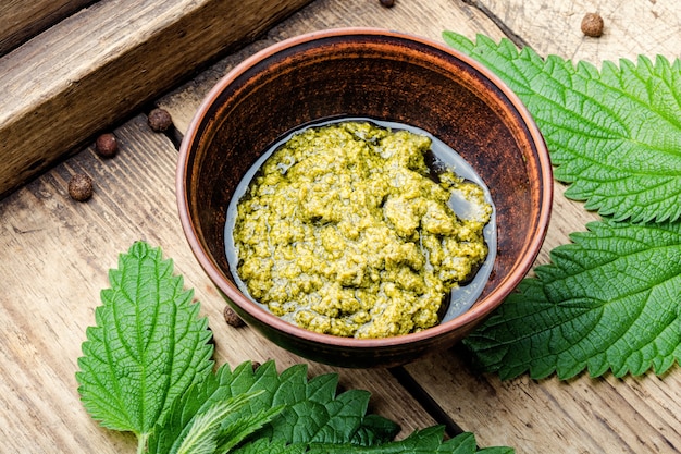 Homemade summer nettle leaf sauce.Appetizing herbal sauce in a wooden retro tray