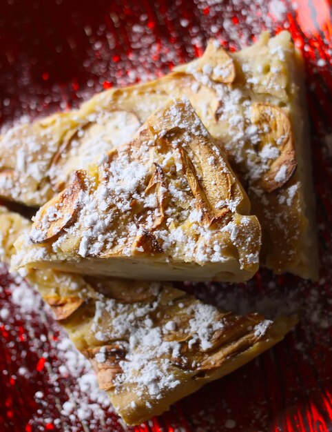 Homemade sweet apple pie with cinnamon and and powdered sugar