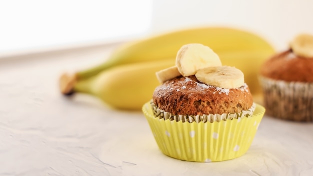 Homemade sweet banana muffins on the marble table on yellow bananas background