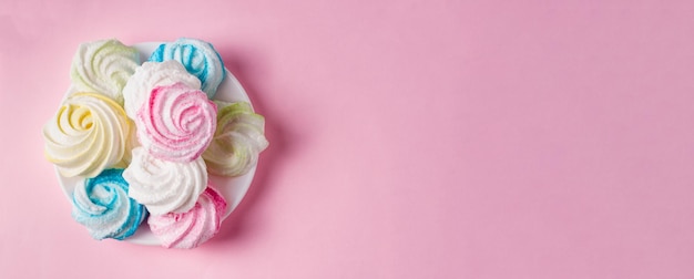 ピンクの背景に卵と砂糖から自家製の甘い色のメレンゲxADessert