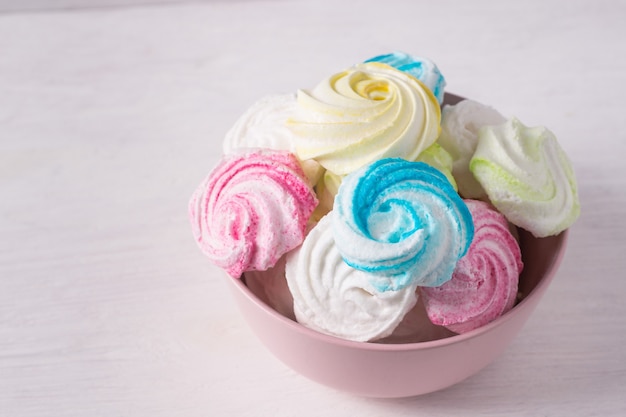 Homemade sweet colored meringue on white