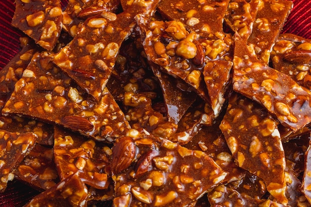 homemade sweet gozinak with various nuts on a red plate christmas concept