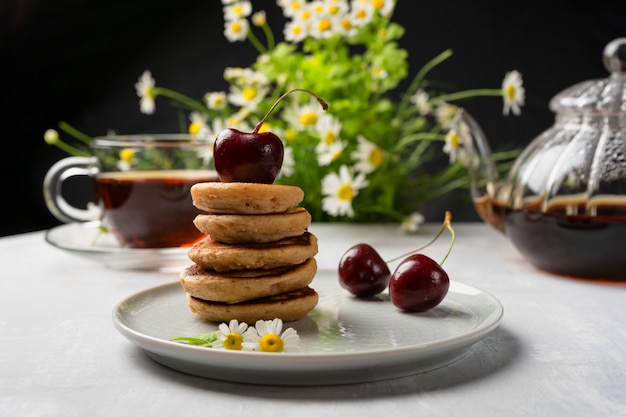 Mini frittelle dolci fatte in casa con marmellata di ciliegie e tè aromatico.