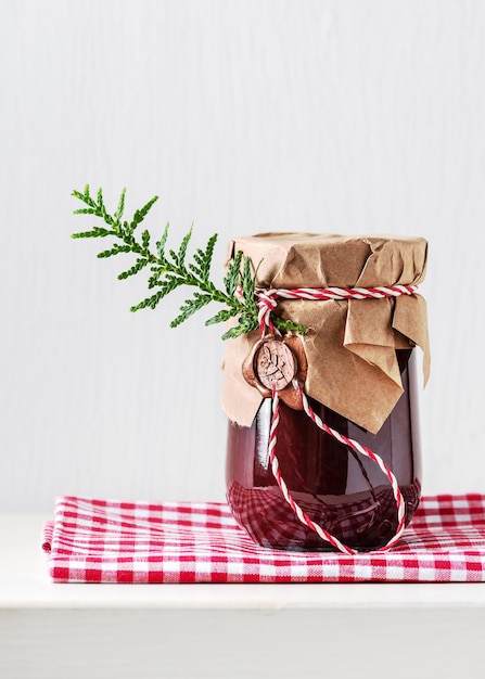 Homemade sweet organic plum jam in a jar decorated with grunge paper and wax seal