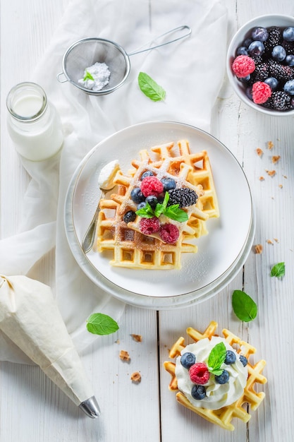 Homemade sweet waffles with berry fruits and whipped cream