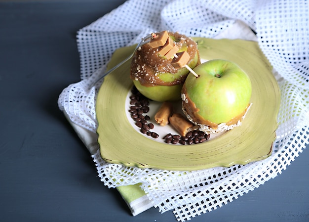 Homemade taffy apples, on napkin, on wooden background