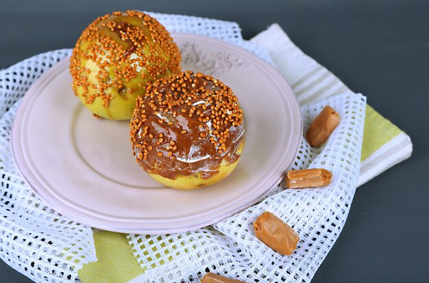 Homemade taffy apples, on napkin, on wooden surface