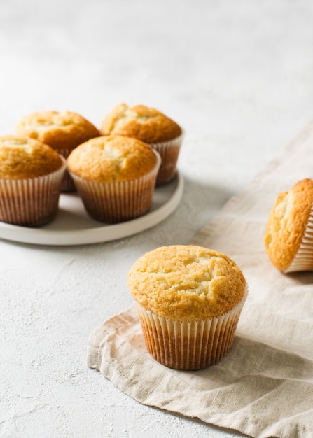 Homemade tasty miffins on white background, copy space, top view, vertical