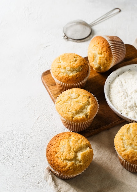 Homemade tasty miffins on white background, copy space, top view, vertical