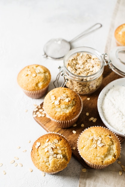 Homemade tasty oat miffins on white background, copy space, top view, vertical