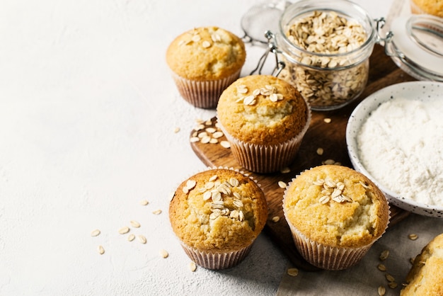 Homemade tasty oat miffins on white background, copy space, top view