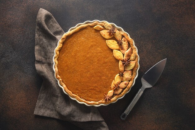 Homemade tasty pumpkin pie with ingredients for thanksgiving day