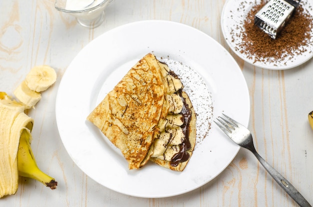 Photo homemade thin pancakes made with oat flour, banana, chocolate and nuts