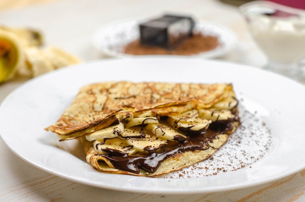 Homemade thin pancakes made with oat flour, banana, chocolate and nuts