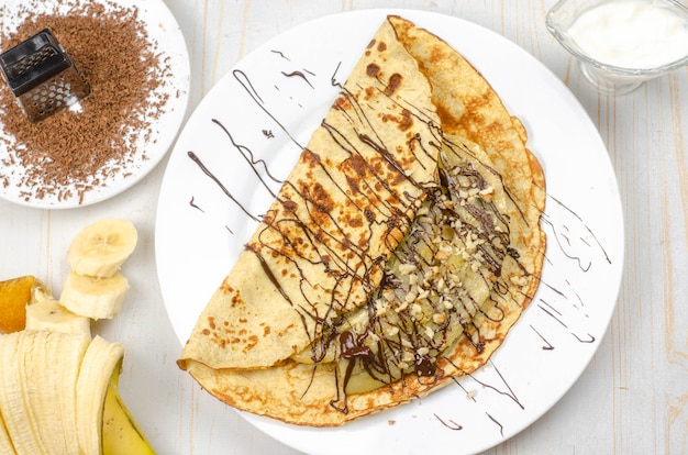 Homemade thin pancakes made with oat flour, banana, chocolate and nuts