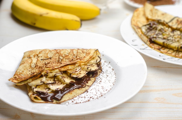 Homemade thin pancakes made with oat flour, banana, chocolate and nuts