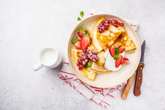 Homemade thin pancakes served with curd cream