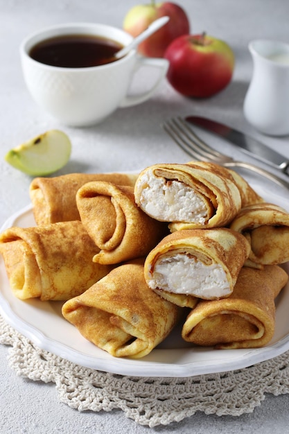 Homemade thin pancakes with cottage cheese and apples for breakfast. Close-up