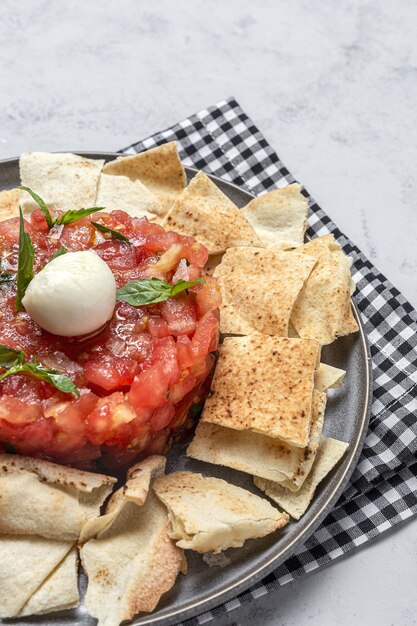 Homemade Tomato Carpaccio Salad with Mozzarella, olive oil and Basil with Arabic Bread. Healthy food concept