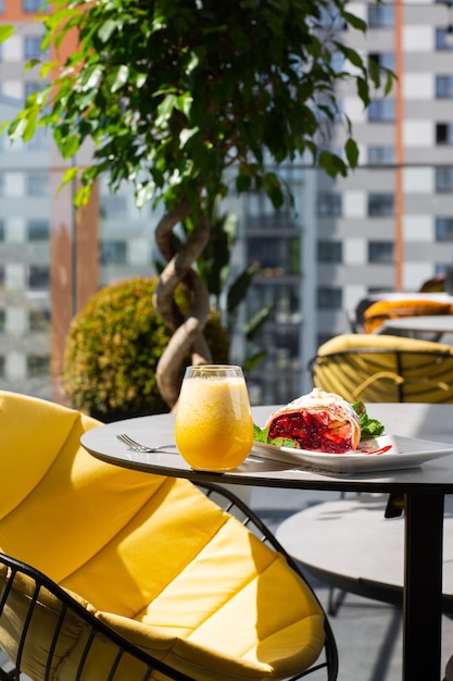 Homemade Traditional Austrian strudel with cherry or red berries and powdered sugar with glass of orange juice. Menu for cafe. Bright background.