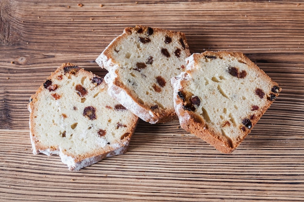 Homemade traditional chopped cupcake with raisins on the wooden background. Closeup, selective focus