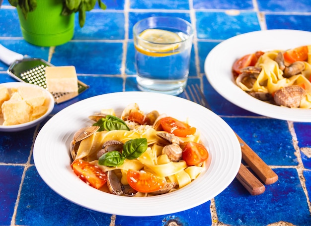 Foto ravioli italiani tradizionali fatti in casa con basilico e pomodoro ciliegino sul tavolo