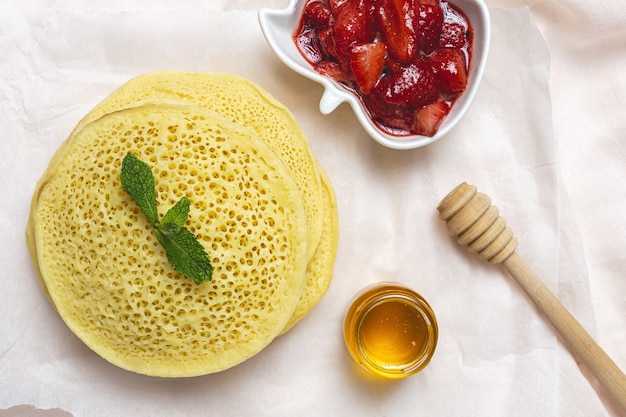 蜂蜜、イチゴ、ミントを使った自家製の伝統的なモロッコ風バグリア。上からモロッコのパンケーキ