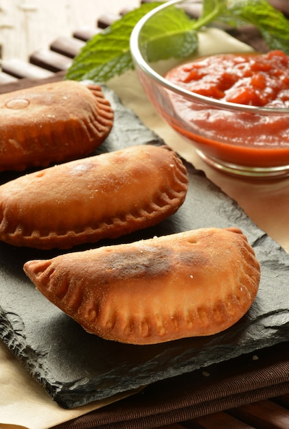 Homemade tuna patty with tomato sauce on wooden table