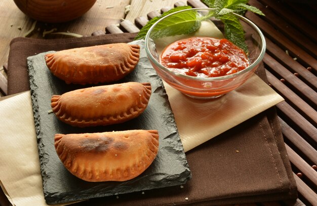 Homemade tuna patty with tomato sauce on wooden table