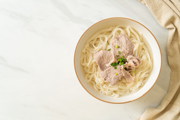 homemade udon ramen noodles with pork in clear soup