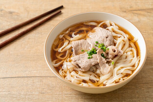 homemade udon ramen noodles with pork in soy or shoyu soup