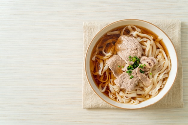 Homemade udon ramen noodles with pork in soy or shoyu soup