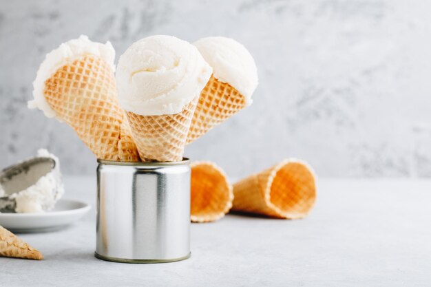 Homemade Vanilla Ice Cream scoop in waffle cones on gray background