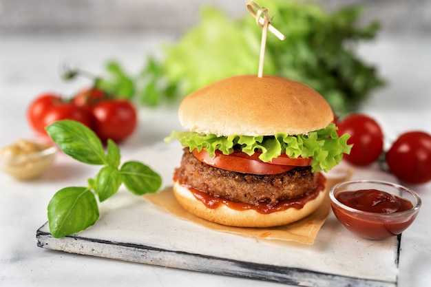 Hamburger casalingo del vegano su superficie rustica bianca
