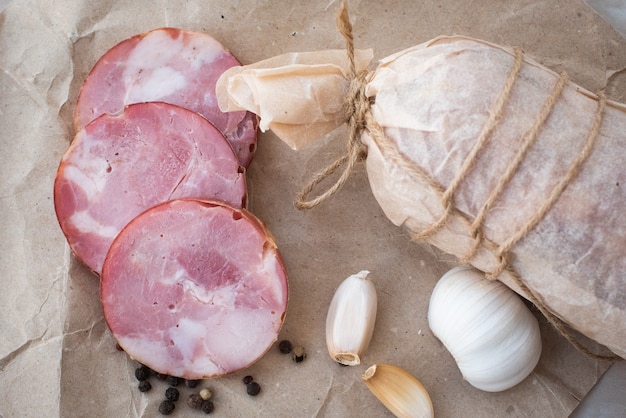 Homemade village ham. pork, red meat. garlic and allspice. decorated in craft paper, tied with a scourge. rustic.