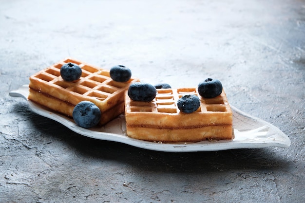 Homemade waffles decorated with blueberries, delicious pastries, dessert.