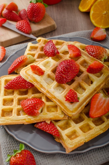 Homemade waffles with maple syrup and strawberries