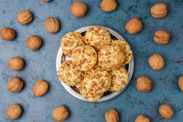 Homemade walnut cookies with walnuts on dark, top view