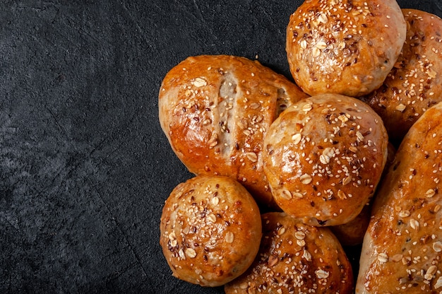 수 제 통 밀 Multigrain 빵과 빵 아마 씨와 어두운 테이블에 참 깨. 평면도 평면 배치. 복사 공간