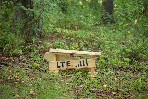 인터넷 신호가 더 잘 포착되는 위치를 보여주는 LTE 비문이 있는 숲속의 수제 나무 벤치