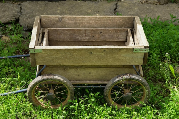 Photo homemade wooden small empty wagon stands in the green grass