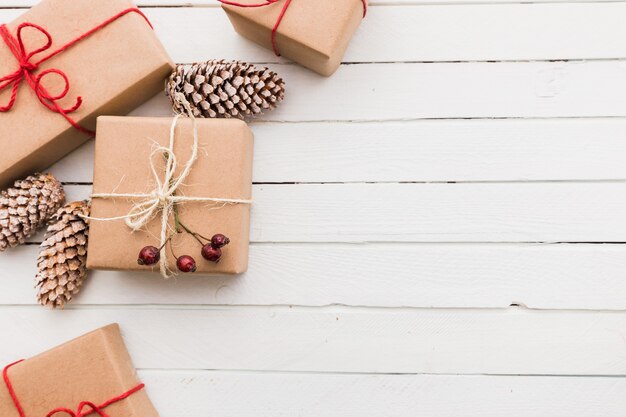 Photo homemade wrapped rustic brown paper packages with various natural things on white wooden surface