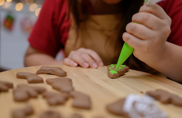 Homemade Xmas cookie for Christmas and Happy New Year. Woman cooking gingerbread with friend and Family on winter holiday at home.