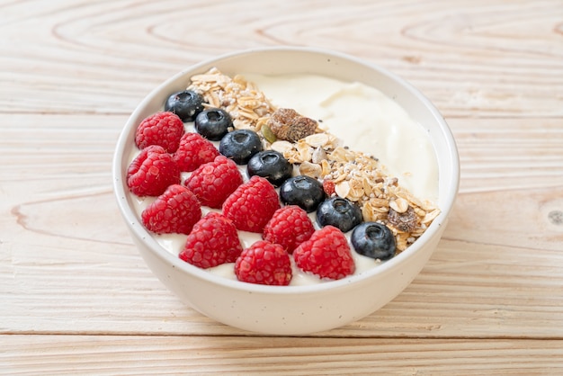 homemade yogurt bowl with raspberry, blueberry and granola  - healthy food style