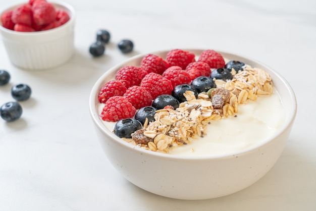 homemade yogurt bowl with raspberry, blueberry and granola  - healthy food style