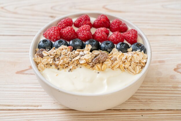 homemade yogurt bowl with raspberry, blueberry and granola  - healthy food style