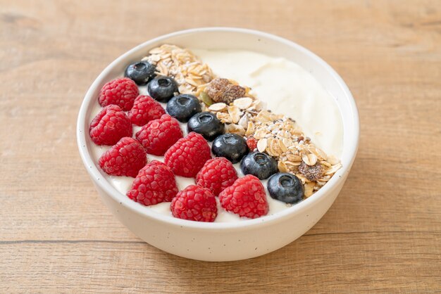 homemade yogurt bowl with raspberry, blueberry and granola  - healthy food style