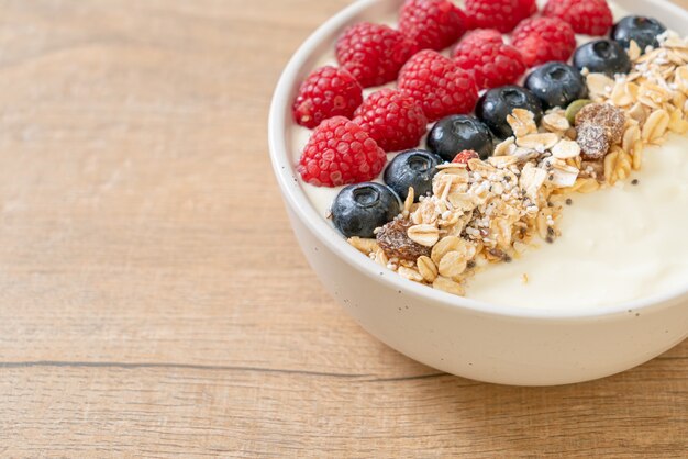 homemade yogurt bowl with raspberry, blueberry and granola  - healthy food style