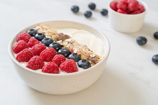 Homemade yogurt bowl with raspberry, blueberry and granola  - healthy food style